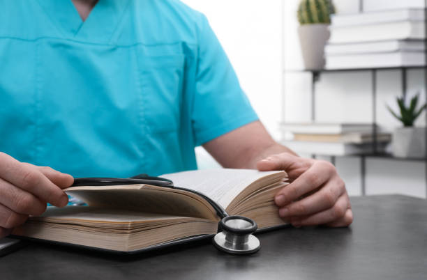 istock Medical student in uniform studying at table indoors, closeup 1452320152