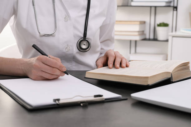 istock Medical student in uniform studying at table indoors, closeup 1452320450