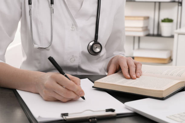 istock Medical student in uniform studying at table indoors, closeup 1452320540