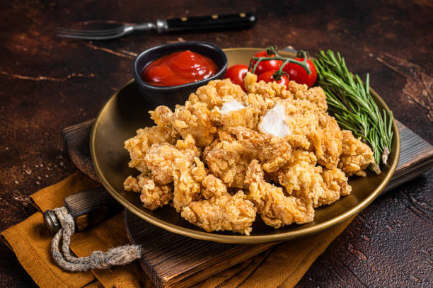 istock Crispy Popcorn Chicken with Barbecue Sauce in a plate. Dark background. Top view 1452320612