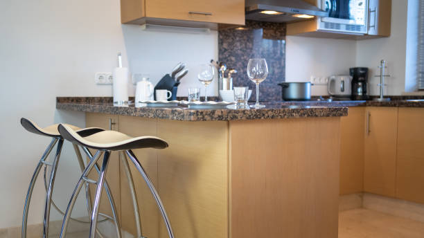 istock Kitchen furniture with stools to sit down to eat and various kitchen utensils above the kitchen countertop. 1452320655