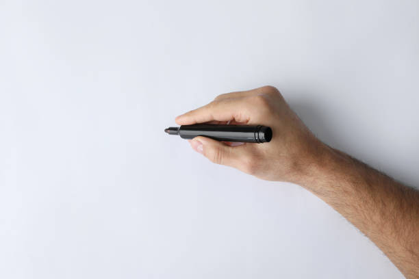 istock Man holding black marker on white background, top view 1452321194