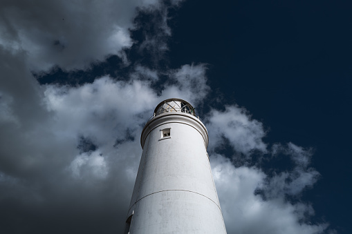 Impressive view of a working lighthouse on the Suffolk, UK coastline. Seen bright against a dark sky.