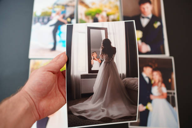 istock printed wedding photos on a black background and in hand. 1452324831