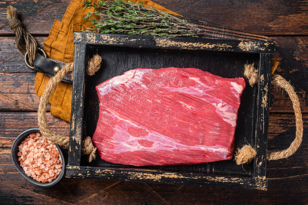 草はハーブと木製のトレイで生のフランクビーフ肉ステーキを供給しました。木製の背景。トップビュー - grass fed ストックフォトと画像