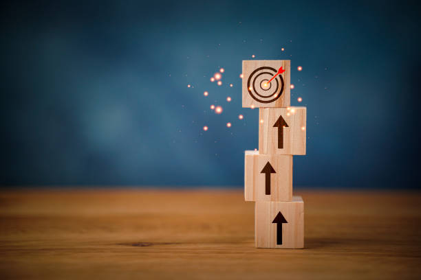 Arranging wood block stacking as step stair with arrow up. Ladder career path concept for business growth success process