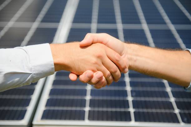 istock Two people having a shaking hands against solar panel after the conclusion of the agreement in the renewable energy 1452328891