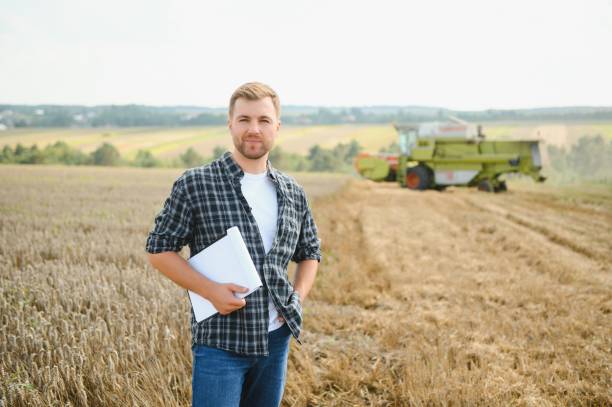 istock Farmer Standing In Wheat Field At Harvest 1452332121
