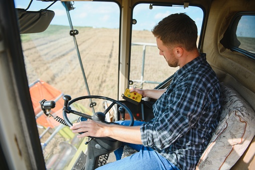 Farmer controls the combine harvester