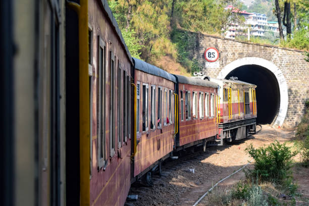 Toy Train moving on mountain slopes, beautiful view, one side mountain, one side valley moving on railway to the hill, among green natural forest. Toy train from Kalka to Shimla in India, Indian Train