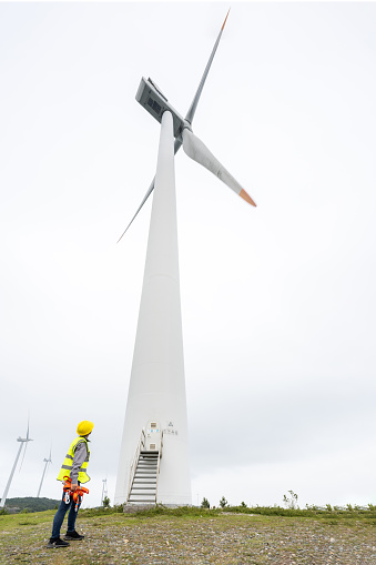 A female engineer works in a mountain wind power station