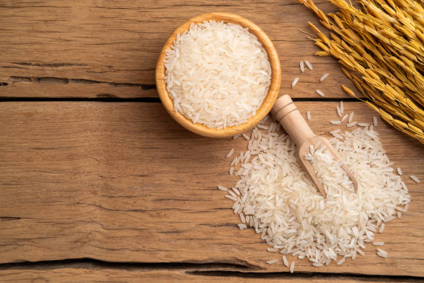 istock Uncooked white jasmine rice in wooden bowl 1452340118