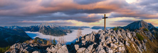 vista nebbiosa del crepuscolo delle alpi autunnali dalla piattaforma panoramica jenner, schonau am konigssee, parco nazionale di berchtesgaden, baviera, germania. pittoresca scena di bellezza itinerante, stagionale e naturale. - cross autumn sky beauty in nature foto e immagini stock