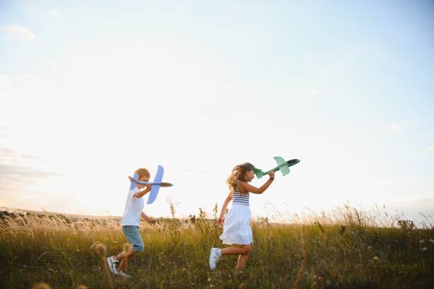 istock Active running kids with boy holding airplane toy. 1452341358