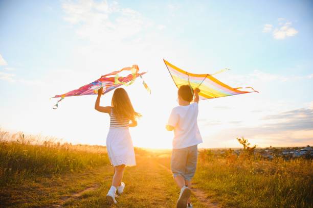 istock Children running with kite in the field. 1452341471