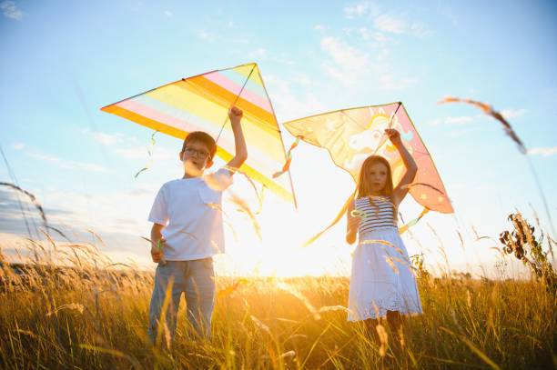 istock Children running with kite in the field. 1452341480