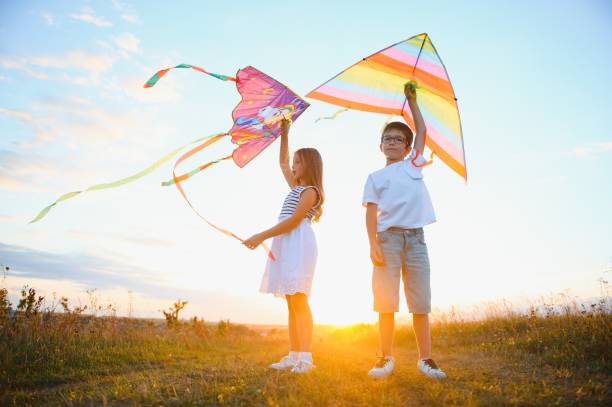 istock Children running with kite in the field. 1452341535