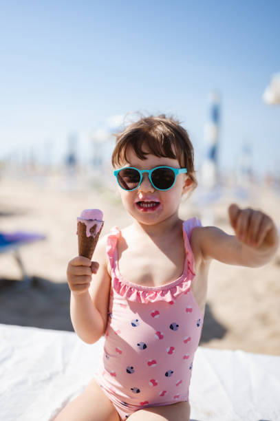 istock Cute girl having ice cream at the beach 1452345209