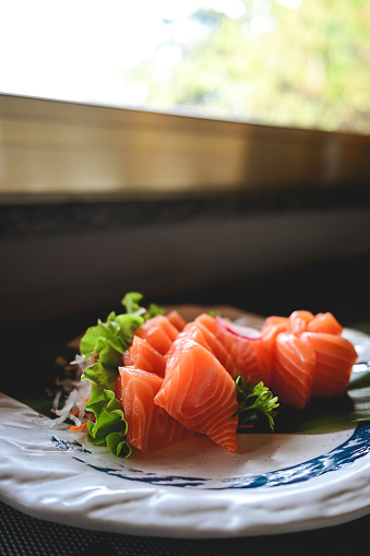 close up of raw salmon on a plate with salad. selective focus, copy space.