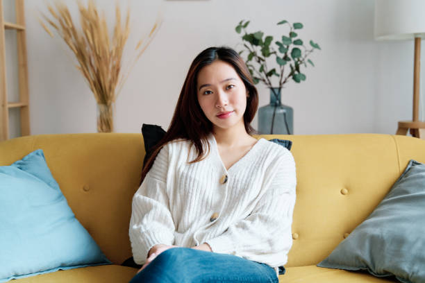 istock Smiling woman sitting on sofa 1452357231