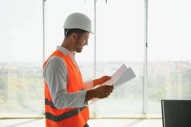istock Portrait of an architect builder studying layout plan of the rooms, serious civil engineer working with documents on construction site, building and home renovation, professional foreman at work. 1452358077