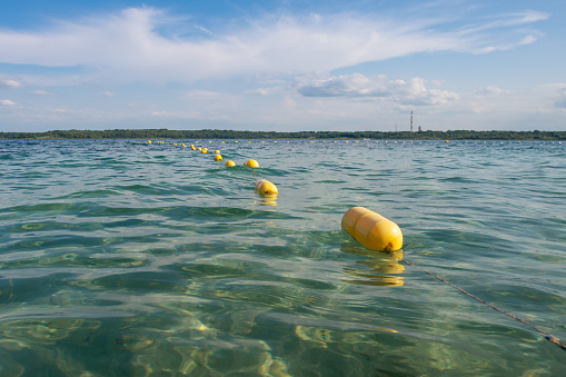 Yellow buoy line floating on the tranquil water. Zone of safety swimming.
