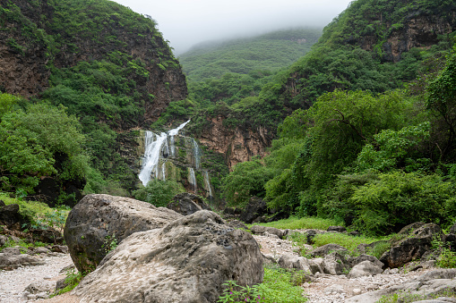 Waterfall and rock pool at Ayn Khor close to Salalah in Oman during the autumnal rain season