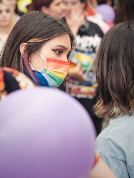 jeunes filles attrayantes participant au rassemblement du défilé de la fierté lgbtq. - symbols of peace flag gay pride flag banner photos et images de collection