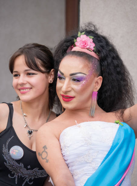 une fille et une drag queen posant lors d’un rassemblement du défilé de la fierté lgbtq - symbols of peace flag gay pride flag banner photos et images de collection