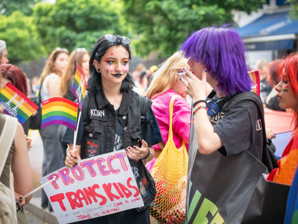 bucarest, roumanie - juillet 2022: de nombreuses personnes assistent au rassemblement du défilé de la fierté lgbtq. bannière pour enfants trans - symbols of peace flag gay pride flag banner photos et images de collection