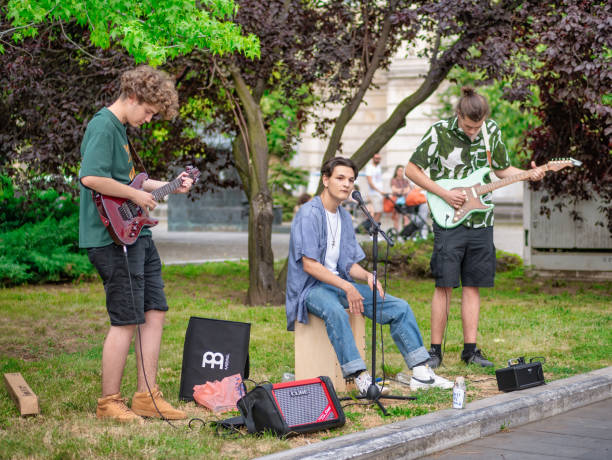 band of young street artists with a guitar playing and singing in the center of bucharest. - 6646 imagens e fotografias de stock