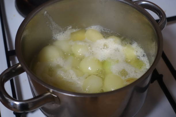 istock Baby onions blanched in boiling water in a saucepan 1452362332
