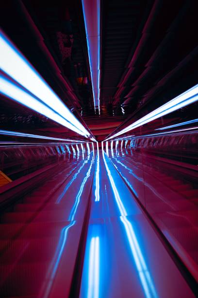 istock Vertical shot of light streaks formed by under-railing lighting on an escalator 1452363247
