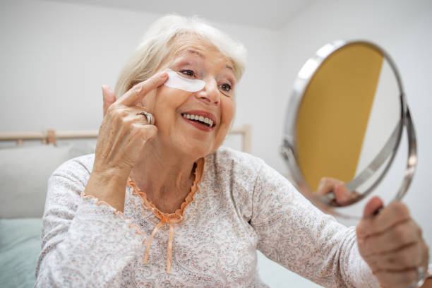 istock Senior woman applying under eye patches at home 1452366461