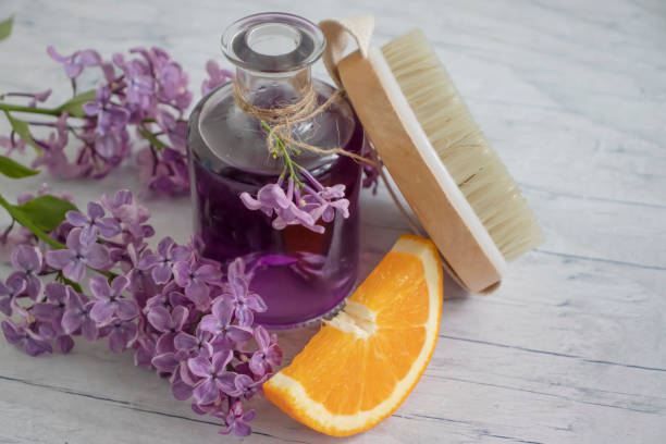 istock Massage brush, cream, lilac flower, orange on a light background 1452372531