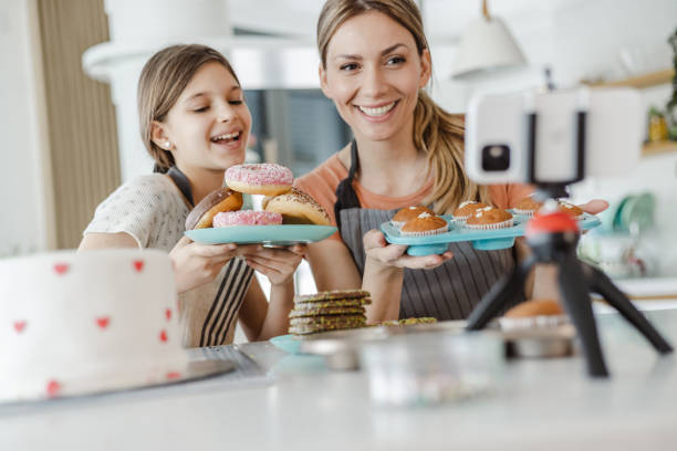 istock Female vlogger filming a tutorial together with her daughter about decorating a sweets 1452375903