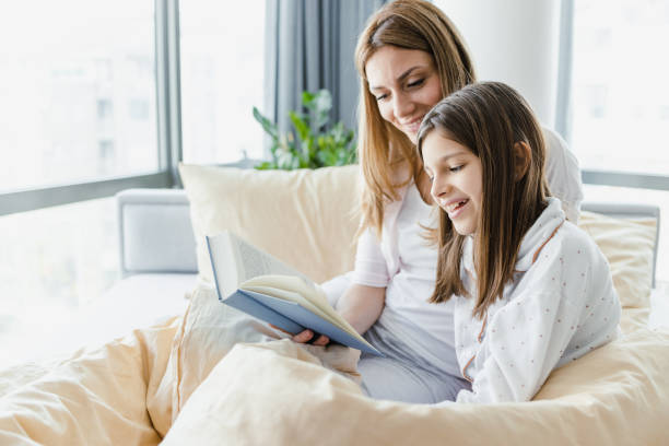 istock Mother is reading a book to her daughter in bed 1452376056