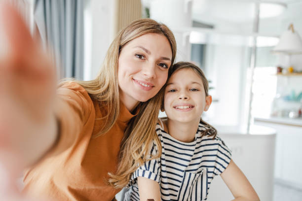 istock Mother and daughter taking a selfie at home 1452376256