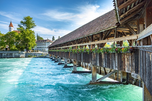 The beautiful Chapel bridge in Thun, Switzerland over a turquoise lake