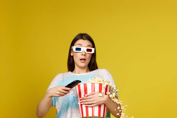 istock woman with remote control holding bucket of popcorn 1452378921