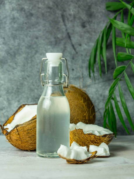 istock fresh refreshing Coconut water in a bottle with an open coconut with white pulp on a concrete background. 1452381174