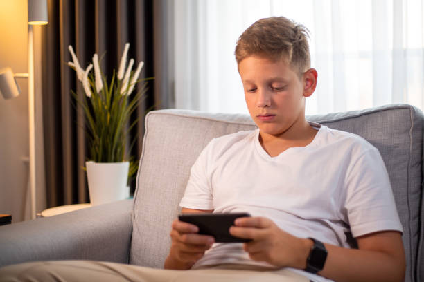 istock Teenage boy playing a mobile game at home 1452381342