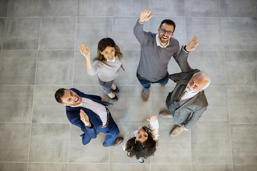 Group of business people looking very happy, and working inside modern office planing future for the company