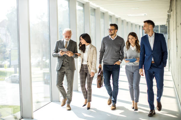 istock Group of business people walking through hallway and talking 1452382609