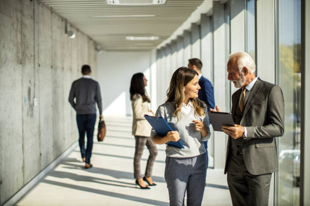 istock Group of business people walking through hallway and talking 1452383434