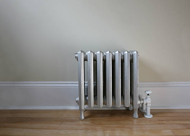istock A silver radiator on wood floor with white and brown walls 145238504