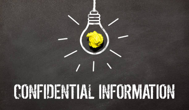 istock confidential information text on the card writes a person's hand next to a yellow notebook on a light background 1452386285