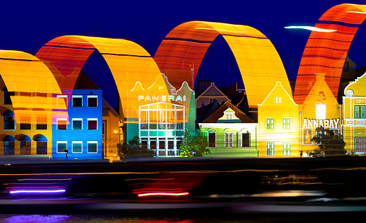 Willemstad, Curacao, Netherlands Antilles - September 13, 2022:      Punda waterfront of downtown Willemstad, Curacao. Light trails from Queen Emma bridge opening at night.