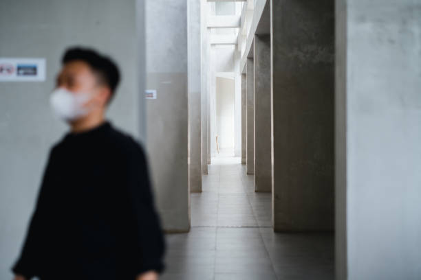 A long, sloped-ceiling corridor at the Hong Kong Cultural Centre, where natural light casts striking diagonal shadows across the patterned floor, highlighting the building’s bold geometric architecture.