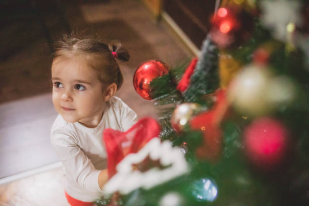 istock Cute little girl decorating christmas tree 1452392787